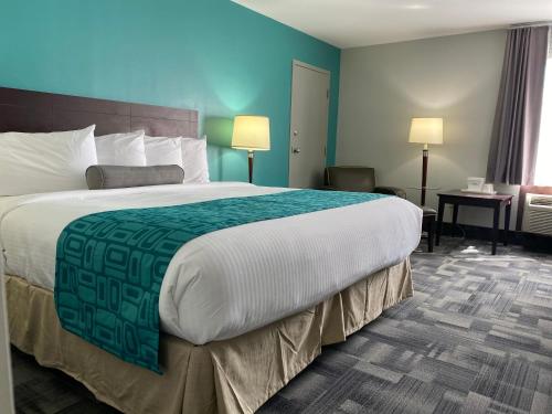a hotel room with a large bed and a desk at Travelodge by Wyndham Miramichi New Brunswick in Miramichi