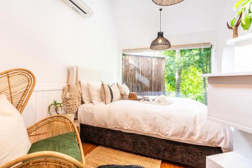 um quarto com uma cama e uma janela em Boho Hill Waiheke Island em Palm Beach