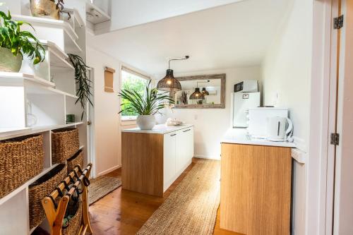 Palm Beach的住宿－Boho Hill Waiheke Island，厨房配有白色橱柜和白色冰箱。