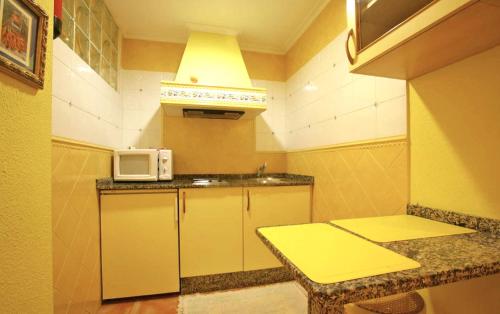 una pequeña cocina con mesa y microondas en Apartamentos Bellavista, en Artedo