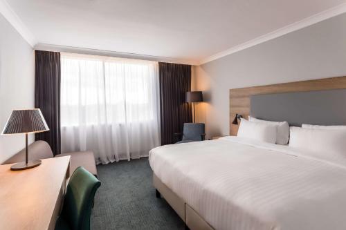 a hotel room with a large bed and a window at Radisson Hotel and Conference Centre London Heathrow in Hillingdon