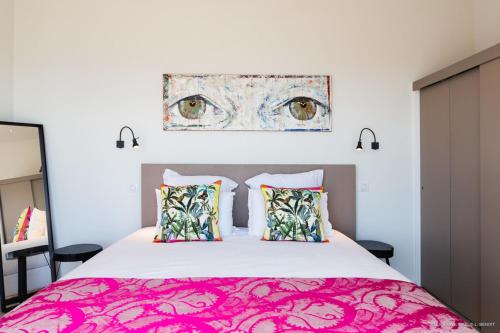 um quarto com uma cama grande e uma colcha rosa em Appart Bleu Caraibe Bord de Mer Breakfast PROMO sur wwwvacancesenmartiniquecom em Les Trois-Îlets