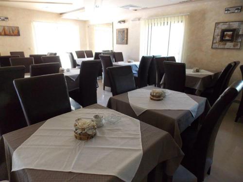 a dining room with tables and chairs with white table cloth at Guesthouse Vila DND in Niška Banja