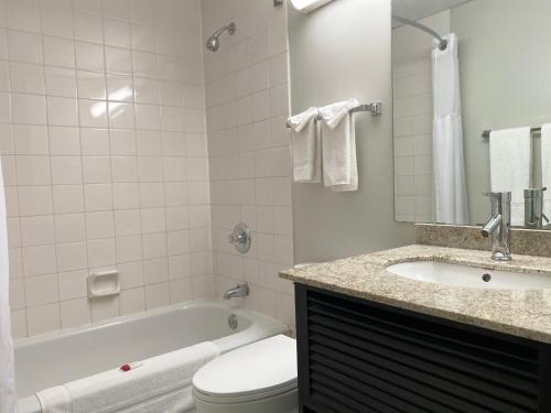 a bathroom with a tub and a toilet and a sink at Travelodge by Wyndham Miramichi New Brunswick in Miramichi