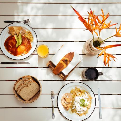 a white table with two plates of food on it at San Trópico Boutique Hotel & Peaceful Escape in Puerto Vallarta