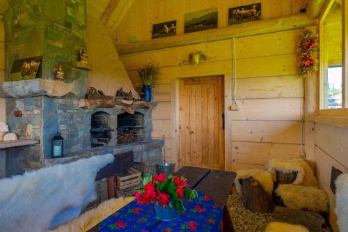 a room with a fireplace and a table in a cabin at Domki Widokowe Wooden Luxury Chalet with Private Jacuzzi in Ząb