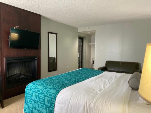 a bedroom with a large bed and a fireplace at Travelodge by Wyndham Miramichi New Brunswick in Miramichi