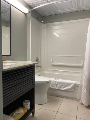 a white bathroom with a toilet and a sink at Travelodge by Wyndham Miramichi New Brunswick in Miramichi