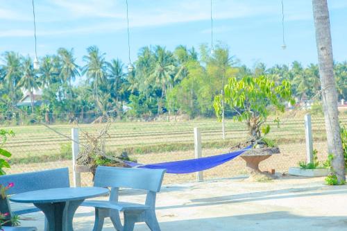 a hammock sitting on a bench next to a fence at Lavender Tan Thanh Hotel mini resort in Cong Thanh (3)