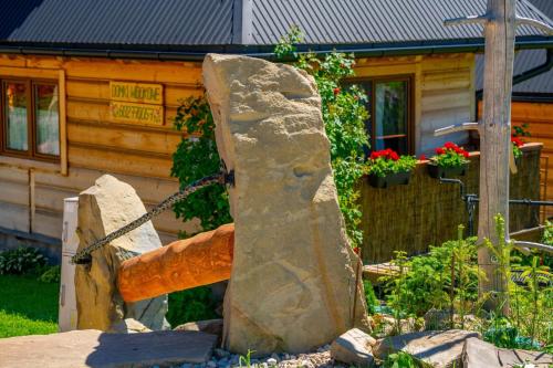a large rock in front of a log cabin at Domki Widokowe Wooden Luxury Chalet with Private Jacuzzi in Ząb