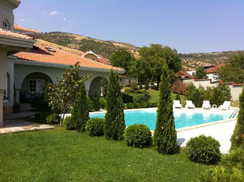 een huis met een zwembad in een tuin bij Sunny House in Skopje
