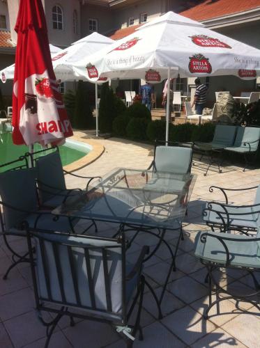 a group of chairs and tables with umbrellas at Sunny House in Skopje