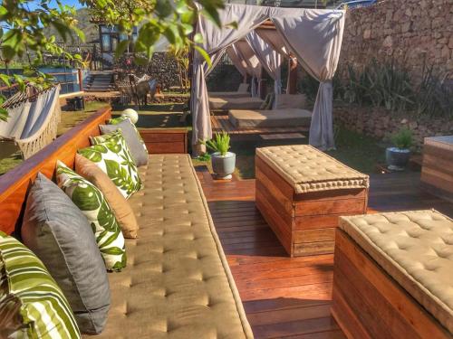 a group of benches with pillows on a wooden deck at Hotel Recanto do Ouro in Ouro Preto