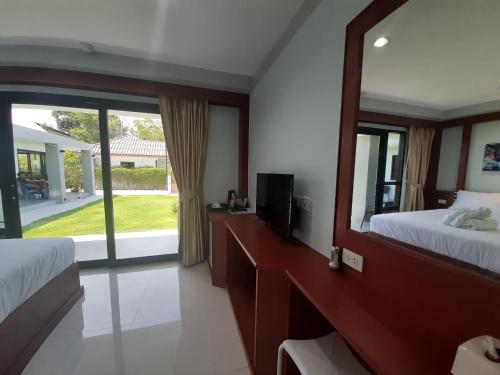 a bedroom with two beds and a large mirror at CC Beach Resort in Khanom