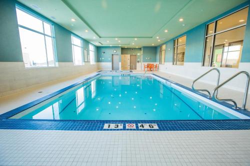 a large swimming pool with blue water in a building at Holiday Inn Express & Suites - West Edmonton-Mall Area by IHG in Edmonton
