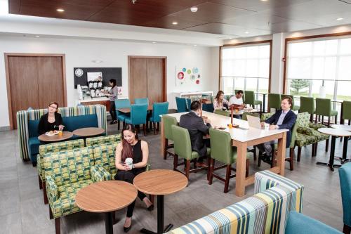 a group of people sitting at tables in a restaurant at Holiday Inn Express & Suites - West Edmonton-Mall Area by IHG in Edmonton