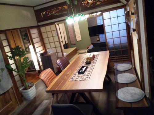a dining room with a wooden table and chairs at Kyoto Villa Kotone in Kyoto