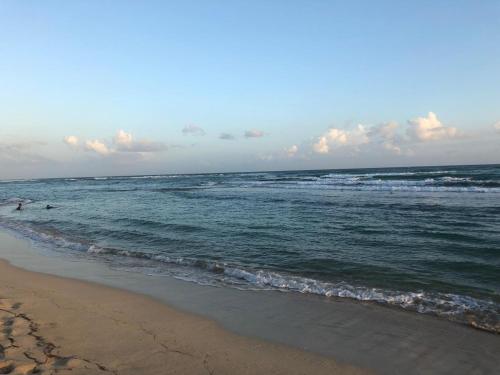a beach with two people swimming in the ocean at La Gaviota A3 in Juan Dolio