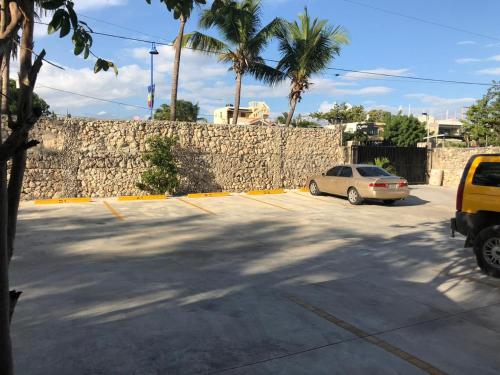 a car parked in a parking lot next to a stone wall at La Gaviota A3 in Juan Dolio