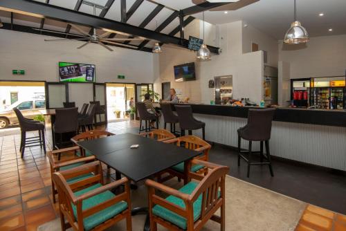 a restaurant with a table and chairs and a bar at Longreach Most Central Motel in Longreach