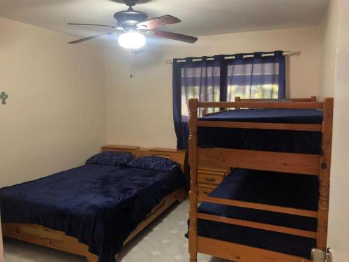 a bedroom with two bunk beds and a ceiling fan at La Gaviota A3 in Juan Dolio
