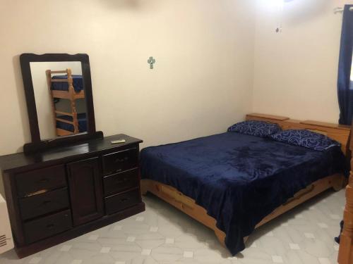 a bedroom with a bed and a dresser and a mirror at La Gaviota A3 in Juan Dolio