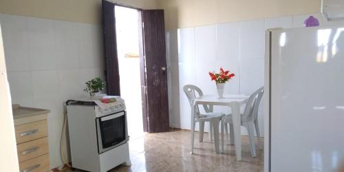 a kitchen with a table and a table and chairs at Casa Bela Paisagem in Mucugê