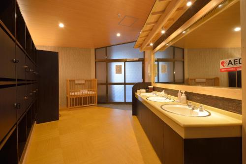 un bagno con due lavandini e un grande specchio di Hakone Kowakien Mikawaya Ryokan a Hakone