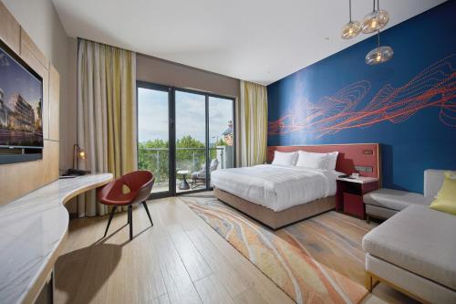 a hotel room with a bed and a tv at Hard Rock Hotel Dalian in Dalian