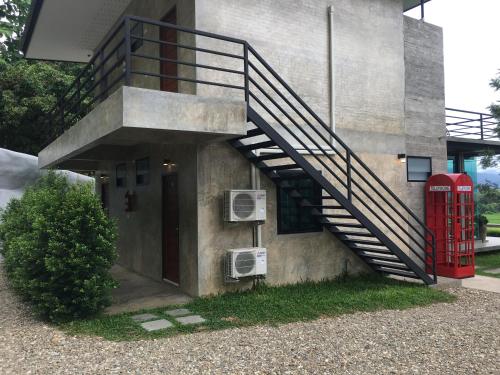 a staircase on the side of a building with a red phone booth at Amante Baristro Hotel & Cafe' @Pua in Nan