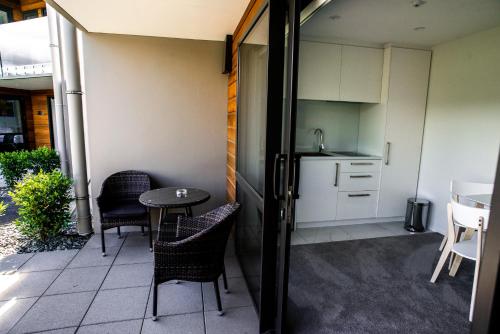 a balcony with a table and chairs and a kitchen at Central Park Apartments in Cromwell