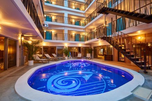 a large swimming pool in a building with a staircase at 8HOTEL Chigasaki in Chigasaki