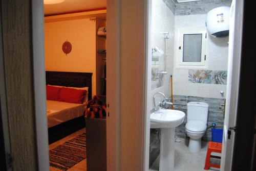 uma casa de banho com uma cama, um lavatório e um WC. em Badr Deluxe Apartments - Families Only em El Alamein