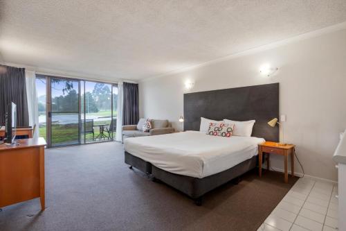 WantirnaにあるKnox International Hotel and Apartmentsのベッドとテレビが備わるホテルルームです。