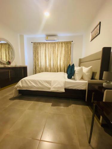 a bedroom with a large bed and a window at OASIS PARK RESIDENCE in East Legon