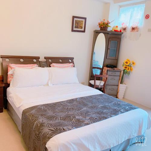 a bedroom with a bed and a dresser and a mirror at 清馨茶園民宿 in Datong