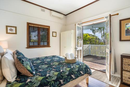 a bedroom with a bed and a door to a porch at Kembali on Massinger Street in Byron Bay