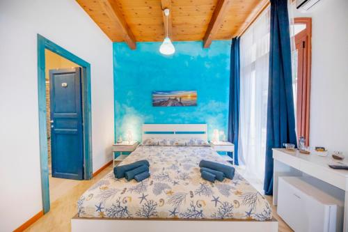 1 dormitorio con 1 cama grande y paredes azules en Borgo Marino Suite B&B, en Cefalú
