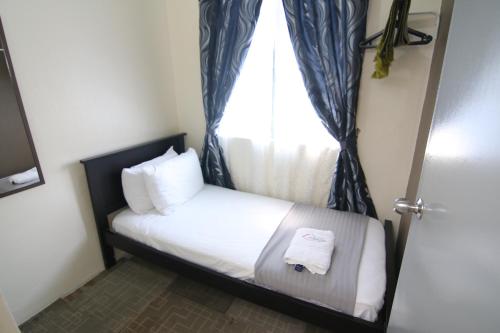 a small bedroom with a bed with a window at Homestay Hj Esmon 3 UTHM Parit Raja in Parit Raja