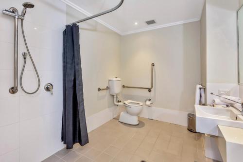 a bathroom with a toilet and a shower and a sink at New Haus by Hougoumont Hotel, former Bannister 22 in Fremantle