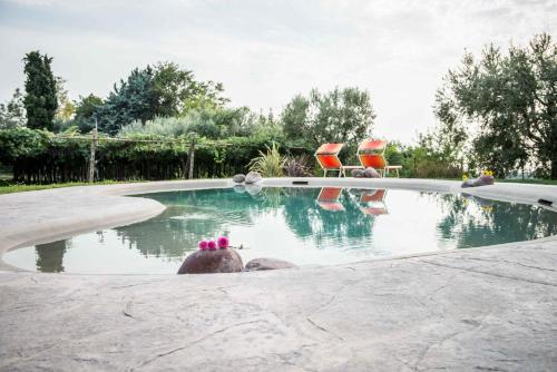 a swimming pool with two chairs and a swimming pool at Agriturismo il Grappolo in Lazise