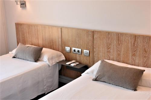 Les PresesにあるHostal Vertisolの木製の壁のベッドルーム1室(ベッド2台付)