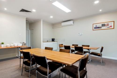 a conference room with a wooden table and chairs at Knox International Hotel and Apartments in Wantirna