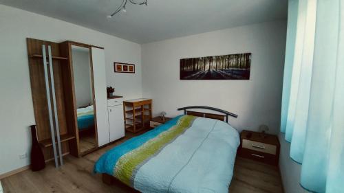 een slaapkamer met een bed en een spiegel bij Chambre d'hôte "Minergy" in Donatyre