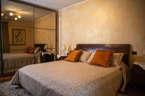 1 dormitorio con cama y espejo grande en La Casolicchia di Arona, en Arona