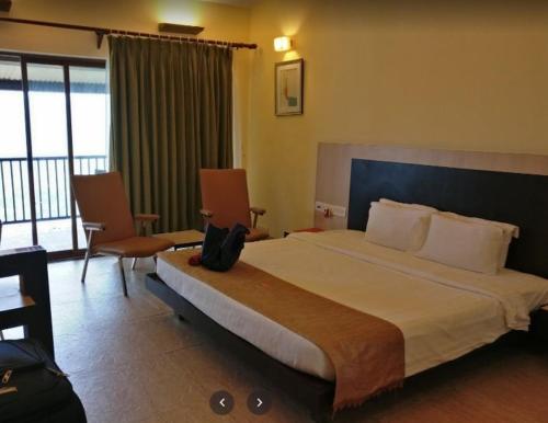 a hotel room with a large bed and a balcony at Ekaant The Retreat in Lavasa
