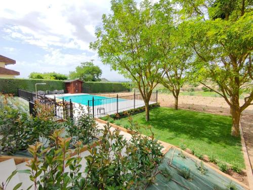 a backyard with a swimming pool and trees at Torre de Briñas Private Resort in Briñas