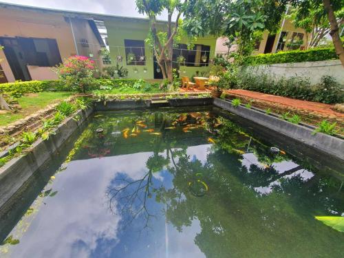 a koi pond in front of a building at Nhà Nghỉ THẢO NGUYÊN XANH in Buon Ma Thuot