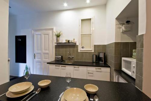 Una cocina con una mesa con platos encima. en Daphne Deluxe Apartment, en Budapest
