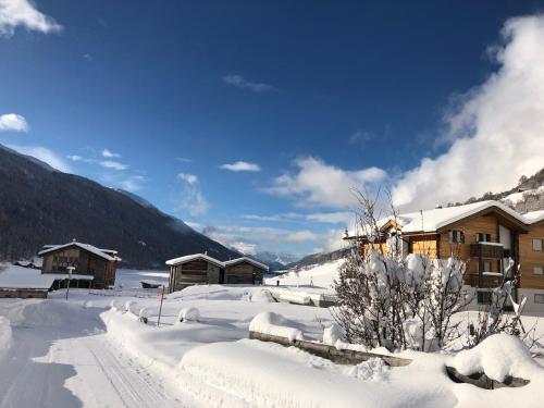 a snow covered village with buildings in the mountains at Chalet Breithorn- Perfect for Holiday with Amazing View! in Obergesteln